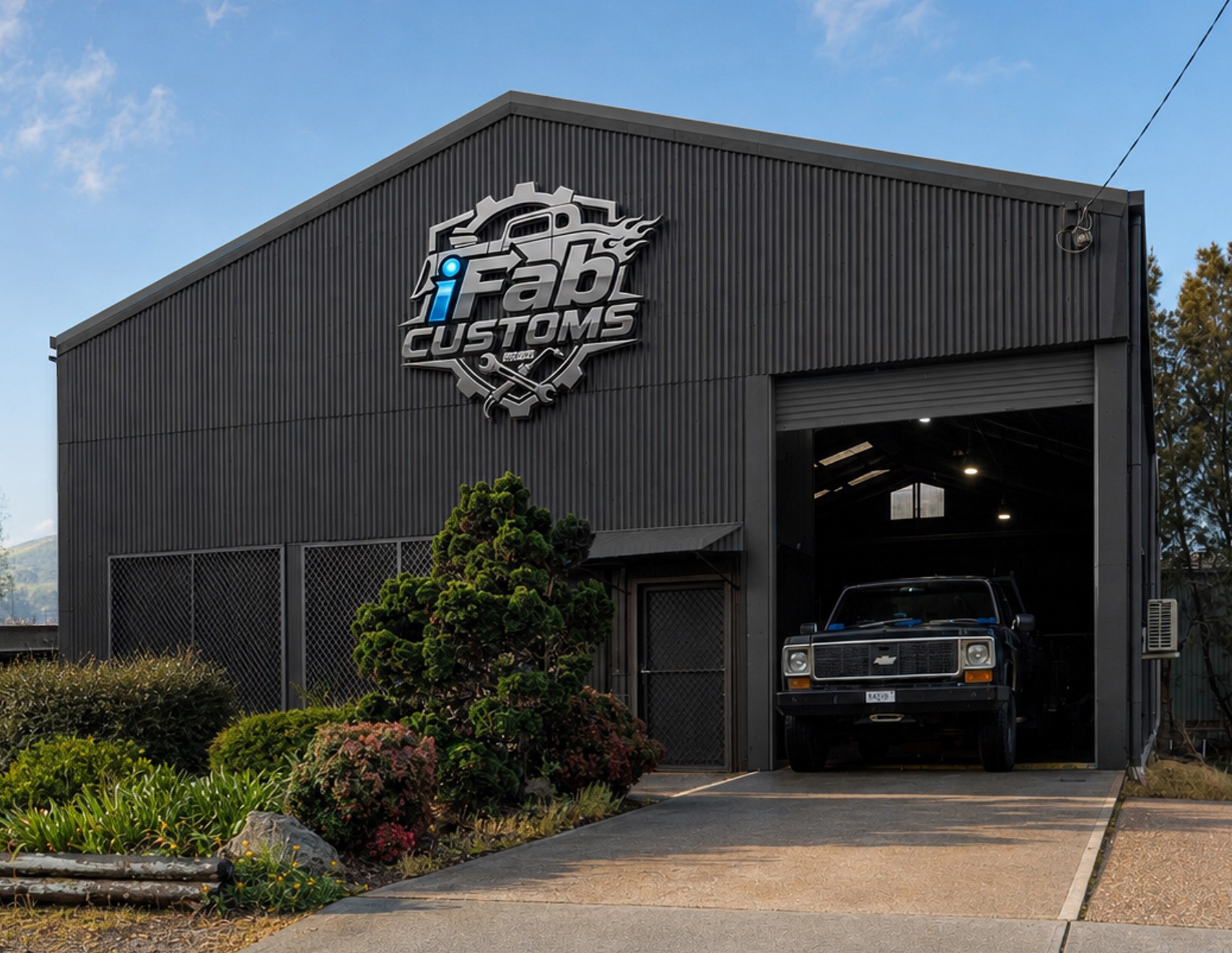The iFab Customs workshop in Taree with the roller door open and a classic Chevrolet truck inside